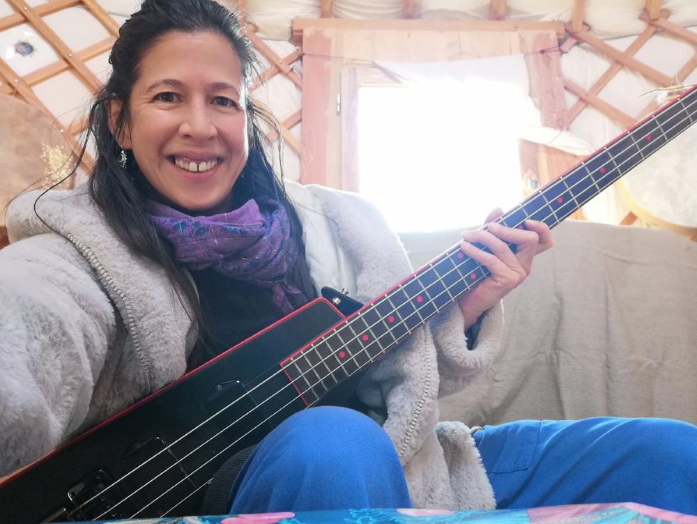 Caroline joue de la basse en souriant
