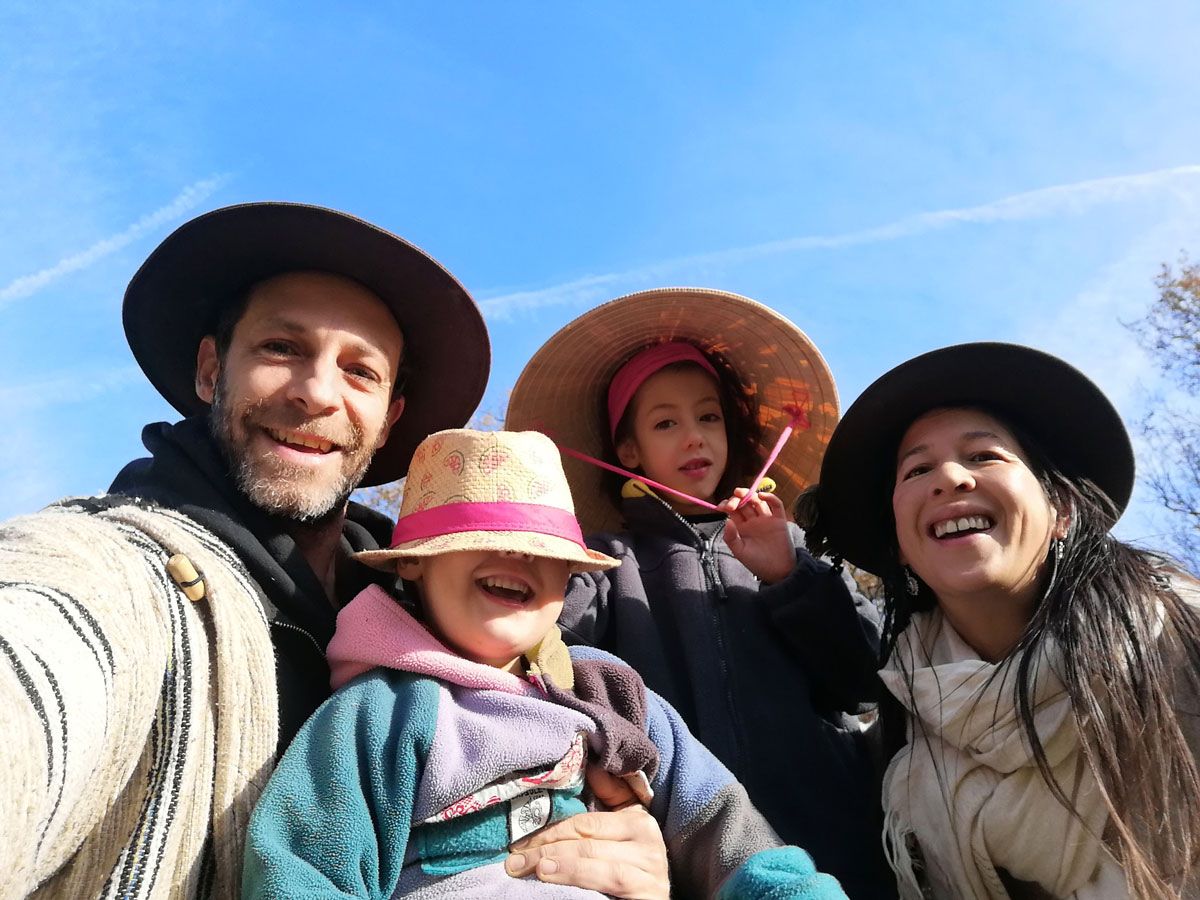 Philippe, Caroline et leurs deux garçons en chapeaux, en selfie sous un ciel bleu