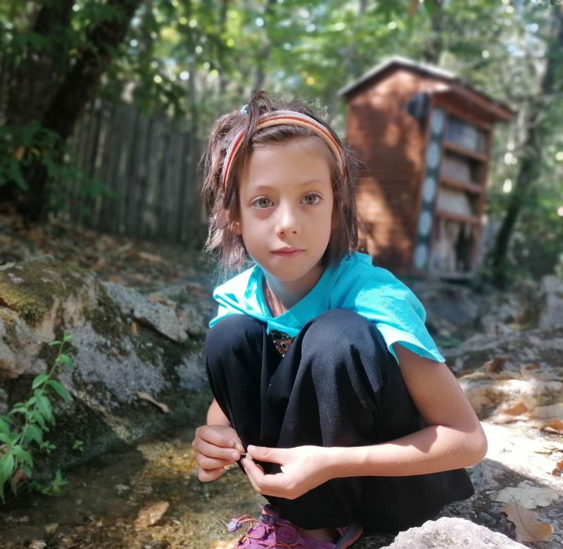 Milo accroupi près d'un ruisseau